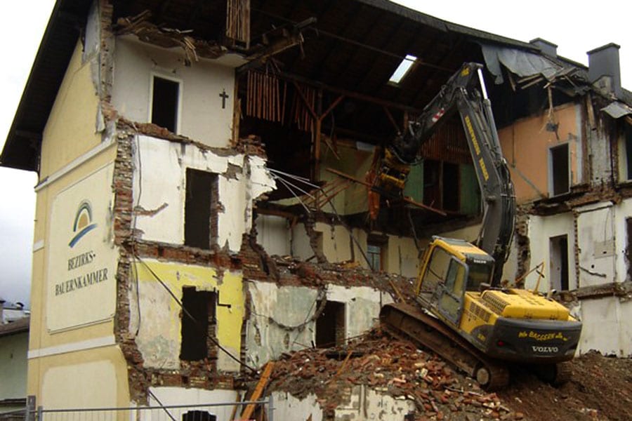 Abbruchbagger mit Sortiergreifer beim Rückbau eines Gebäudes